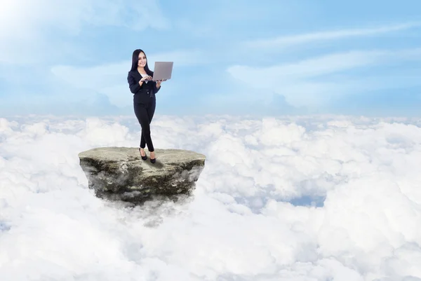 Businesswoman and laptop above clouds — Stock Photo, Image