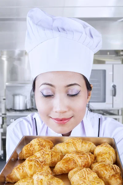 Asian baker smells bread Stock Picture