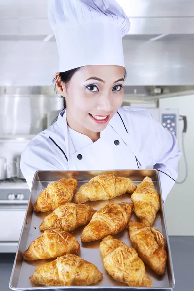 Chef holding croissants in kitchen Royalty Free Stock Images