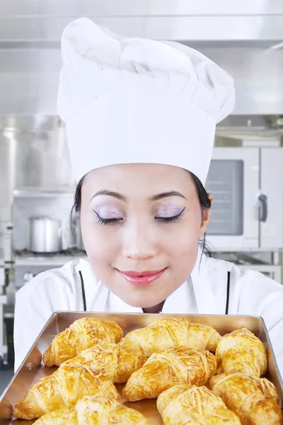Asian baker smells bread Royalty Free Stock Photos