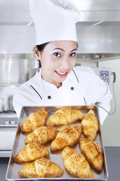 Chef holding croissants in kitchen Stock Photo