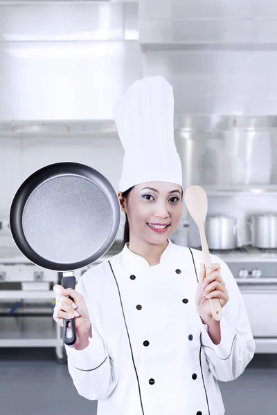 Chef holding pan and wooden spoon Stock Image