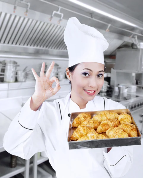 Zufriedener Bäcker mit Croissants Stockfoto