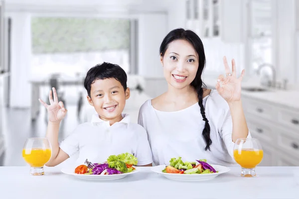 Мальчик и мама довольны салатом — стоковое фото