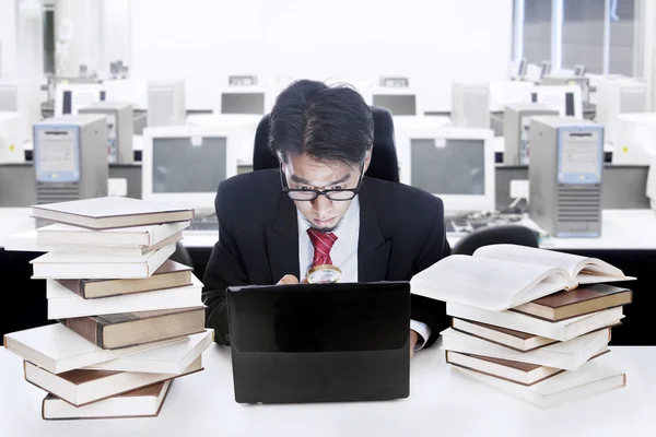 Empresario rodeado de libros y computadoras —  Fotos de Stock