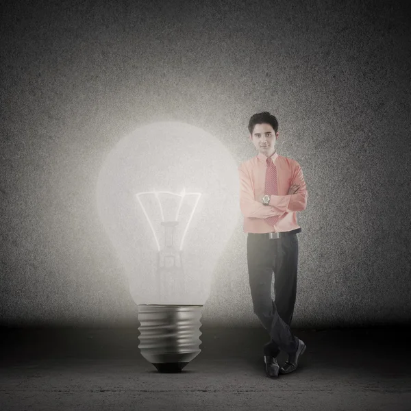 Businessman and bright light bulb — Stock Photo, Image