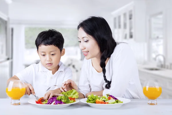 鼓励孩子在家里吃沙拉 免版税图库图片