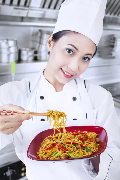Asian chef and fried noodle in kitchen Royalty Free Stock Images