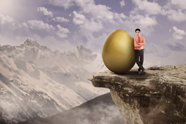 Wirtschaftsführer und goldenes Ei obenauf — Stockfoto