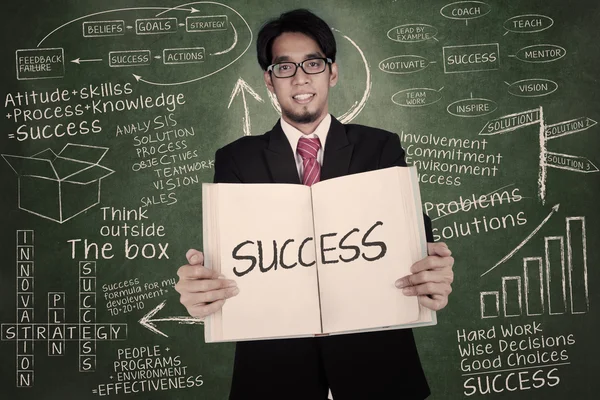 Businessman holding book of success — Stock Photo, Image