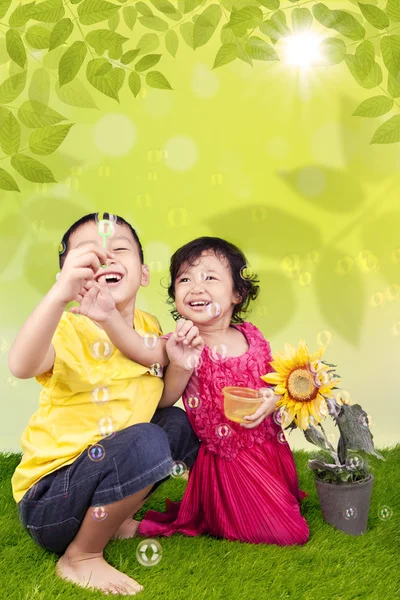 Lindos hermanos soplando burbujas — Foto de Stock