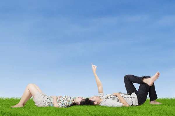 Casal feliz apontando para o céu — Fotografia de Stock