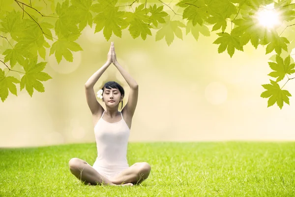 Asiatisk tjej gör yoga på grön park — Stockfoto