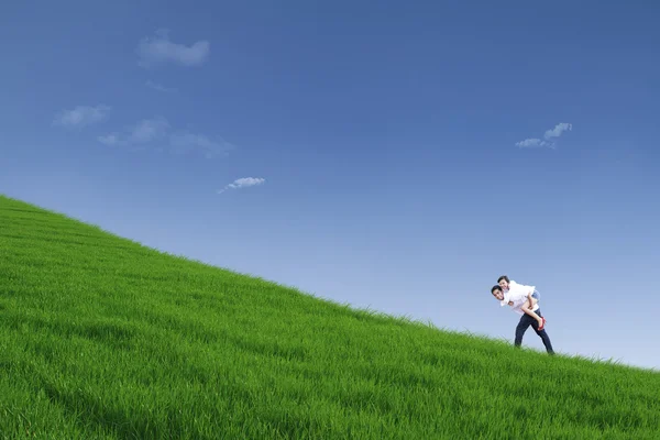 Ragazzo che dà cavalcata sulla collina sotto il cielo blu — Foto Stock