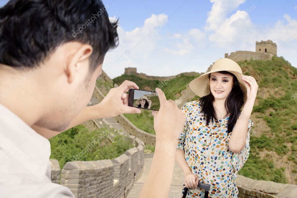 Tourist posing in front of Great Wall in China