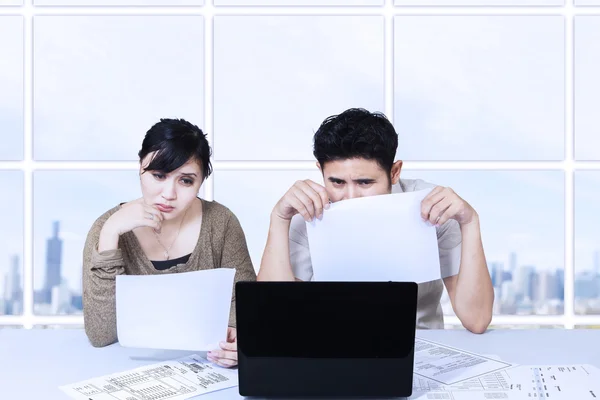 Paar triest kijken laptop in office — Stockfoto