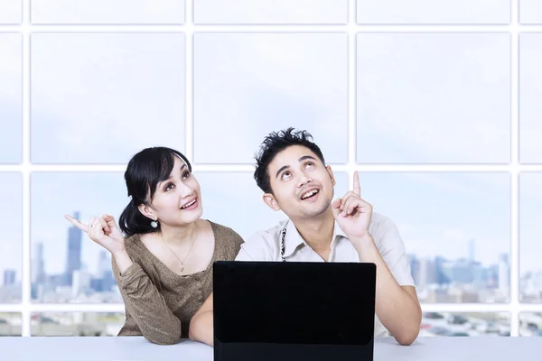 Asian couple looking up in office — Stock Photo, Image