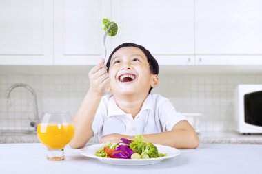 mutlu çocuk yemek brocoli mutfakta