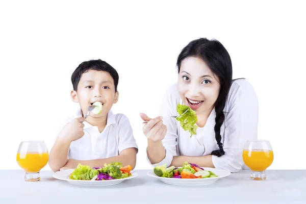 Matka i syn jeść zdrową sałatkę - na białym tle — Zdjęcie stockowe