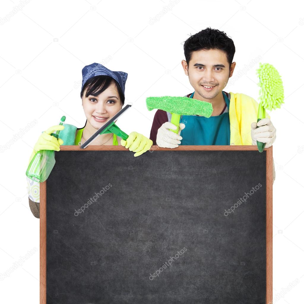 Cleaning service couple holding blackboard