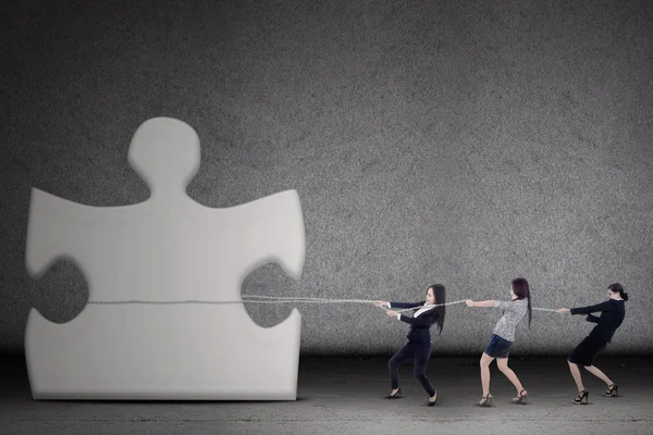 Businesswomen teamwork pull a puzzle — Stock Photo, Image