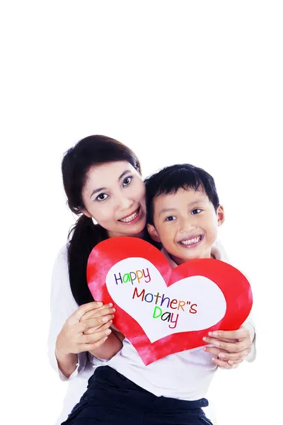 Mãe asiática e filho segurando cartão de amor isolado — Fotografia de Stock