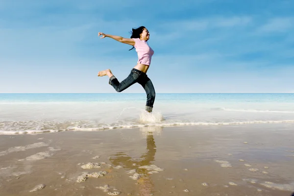 Asiatische Mädchen springen am Strand — Stockfoto