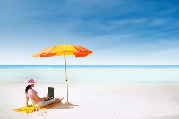 Mujer asiática y portátil en la playa paraíso — Foto de Stock