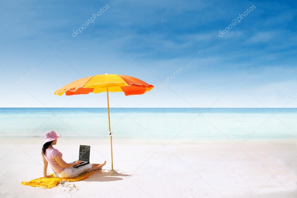 Asian woman and laptop at paradise beach