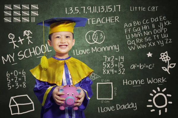 Happy scholar dressed toddler with piggybank — Stock Photo, Image