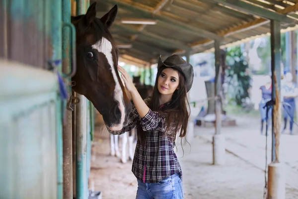 Menina bonita tocando cavalo — Fotografia de Stock