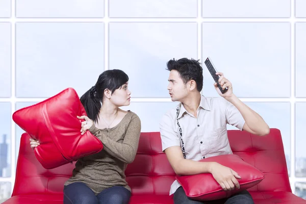 Couple fight on red sofa - indoor — Stock Photo, Image