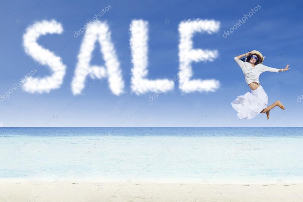 Girl jumping and sale cloud on white sand beach