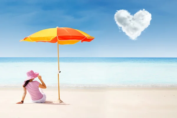 Asiatische Touristen am Strand unter Sonnenschirm und Liebe Wolke — Stockfoto