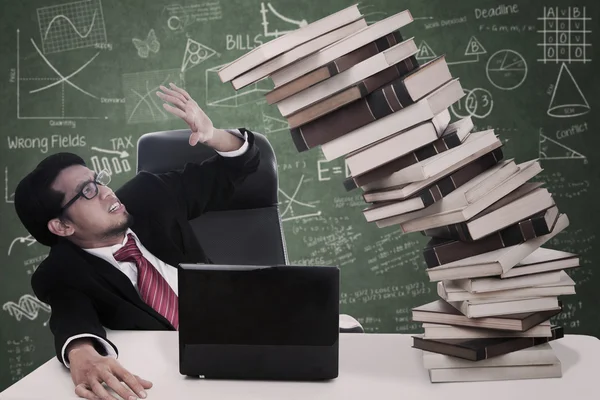 Stress zakenman met dalende boeken op klasse — Stockfoto