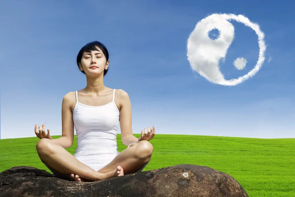 Ejercicio yoga al aire libre bajo ying yang cloud — Foto de Stock