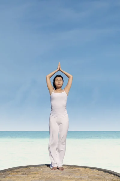 Mujer bonita haciendo yoga en la playa — Foto de Stock