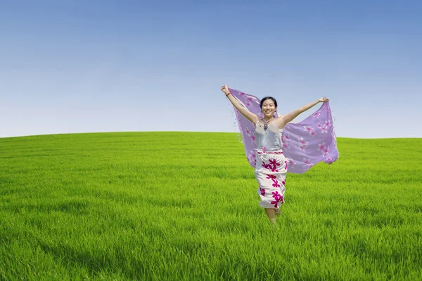 Ασιατική γυναίκα τρέχει στο πράσινο πεδίο — Φωτογραφία Αρχείου
