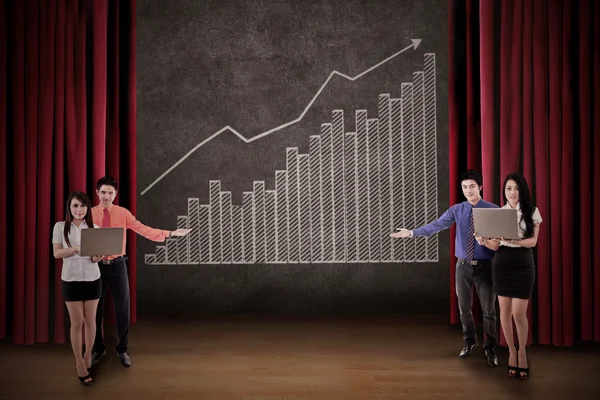 L'équipe d'affaires présente le diagramme à barres de profit sur scène — Photo