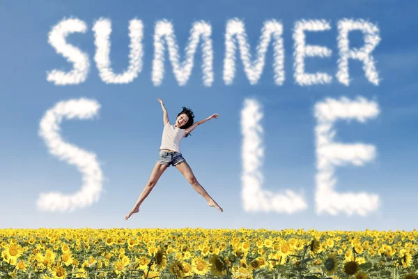 Sommar försäljning moln och kvinna hoppa över solrosor — Stockfoto