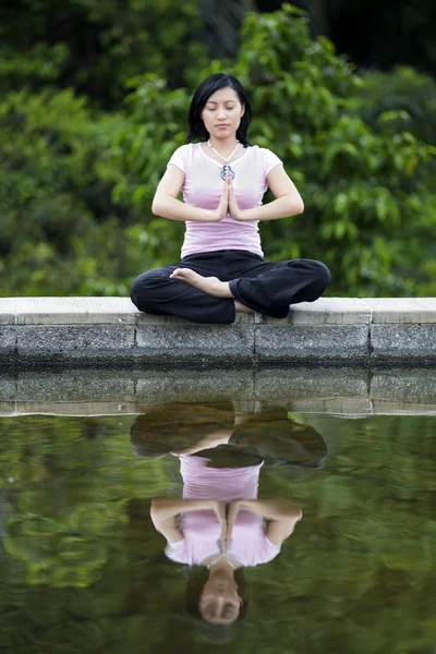 Göl kenarında yoga yaparken Asyalı kadın — Stok fotoğraf