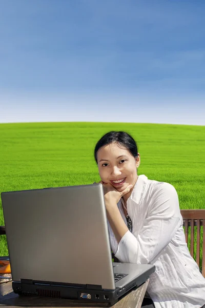 Zakenvrouw werken met laptop in park — Stockfoto