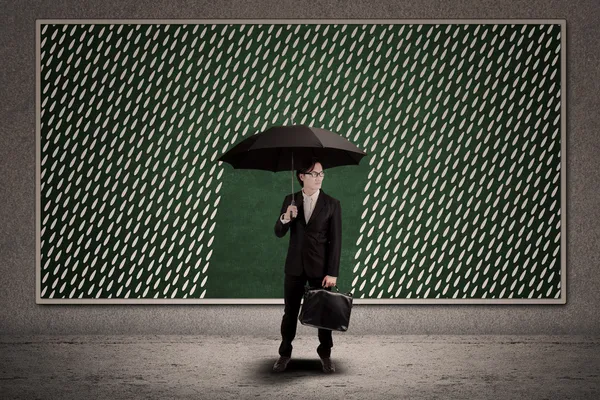 Businessman with umbrella under rain drawing — Stock Photo, Image