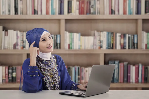 Asiática mujer musulmana pensando en la biblioteca — Foto de Stock