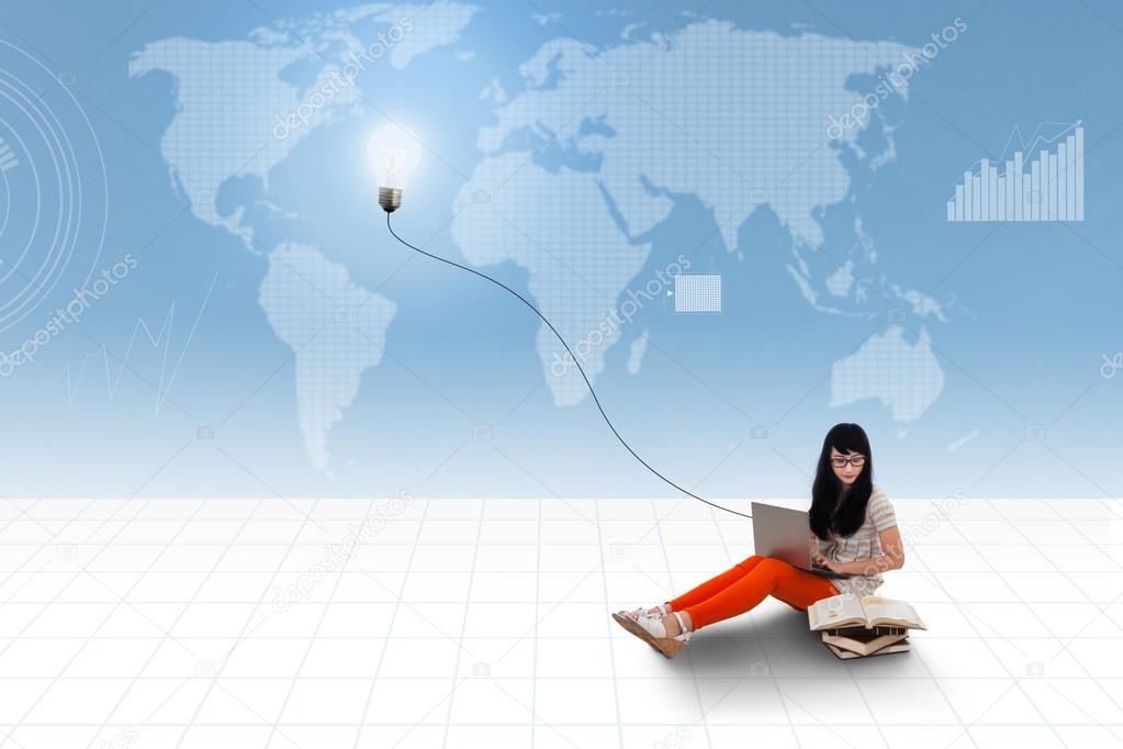 Asian student using laptop on world map background