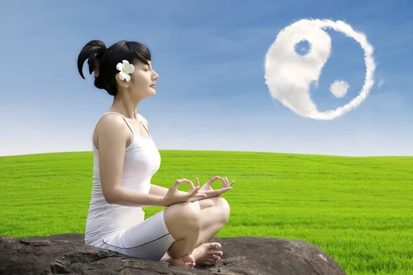 Attractive girl meditate yoga under ying yang cloud — Stock Photo, Image