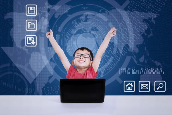 Asiatischer Junge gewinnt mit Laptop auf blauem Hintergrund — Stockfoto