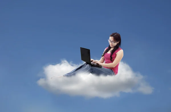 Donna attraente utilizzando laptop su cloud — Foto Stock