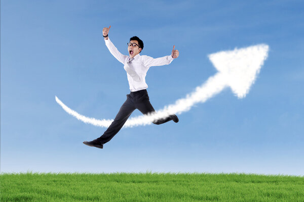 Asian businessman jumping over up arrow sign cloud