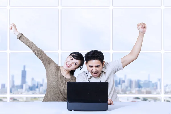 Casal feliz gritando em apartamento usando laptop — Fotografia de Stock